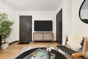 a living room with a table and a flat screen tv at HostWise Stays - Prime Butler St Location - Lower Lawrenceville in Pittsburgh