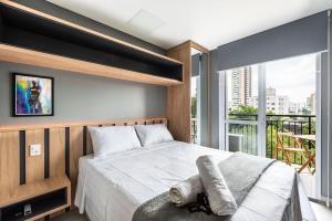 1 dormitorio con cama y ventana grande en HO3 - Studio na Vila Mariana: Moderno e Completo., en São Paulo
