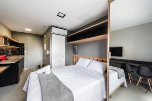 1 dormitorio con 1 cama blanca y cocina en HO3 - Studio na Vila Mariana: Moderno e Completo., en São Paulo