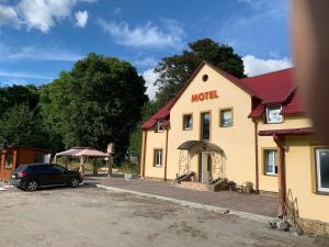 a building with a car parked in front of it at Мотель «Паляниця» in Bokiyevka