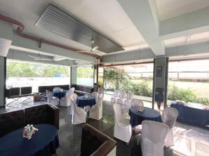 a restaurant with blue tables and white chairs at HOTEL AIRPORT KK in Nagpur