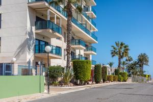 an empty street in front of a building with palm trees at Vista al Mar, Ferienwohnung, Traumhafter Meerblick, Seaview in Torrevieja