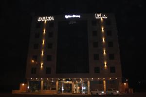 budynek z znakiem na górze w nocy w obiekcie Delta Hotel Suites w mieście Dżizan