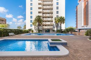 a swimming pool in front of a tall building at Vista al Mar, Ferienwohnung, Traumhafter Meerblick, Seaview in Torrevieja