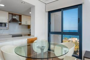a kitchen with a glass table and white chairs at Vista al Mar, Ferienwohnung, Traumhafter Meerblick, Seaview in Torrevieja