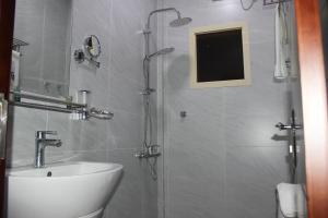 a bathroom with a shower with a sink and a toilet at Delta Hotel Suites in Jazan