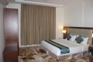 um quarto de hotel com uma cama grande e uma janela em Delta Hotel Suites em Jazan