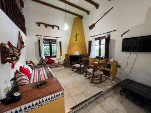 ein Wohnzimmer mit einem Sofa und einem TV in der Unterkunft Casa Lirios in Jimera de Líbar
