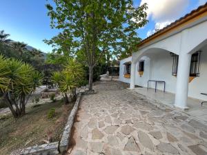 einen Steinweg neben einem weißen Gebäude in der Unterkunft Casa Lirios in Jimera de Líbar