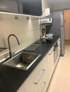 a kitchen with a sink and a black counter top at Apartamento Golf PANORAMICA in Sant Jordi