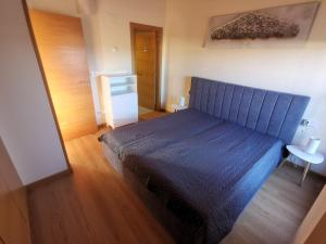 1 dormitorio con 1 cama azul en una habitación en Apartamento Golf PANORAMICA en Sant Jordi