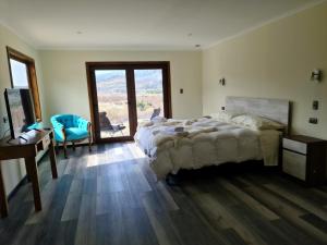 1 dormitorio con cama, escritorio y ventana en Hotel HORSTMEYER, en Cochrane
