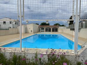 duży basen z niebieską wodą w obiekcie Agréable maison, plage à 400m, jardin, piscine et tennis w mieście Saint-Palais-sur-Mer