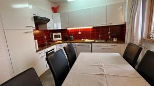 a kitchen with a table and chairs and a kitchen with white cabinets at Alberti 5 in Davos