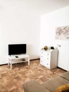 a living room with a tv and a white dresser at Casas dos Avós in Nazaré