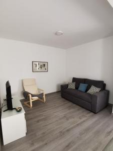 a living room with a couch and a chair at Casas dos Avós in Nazaré