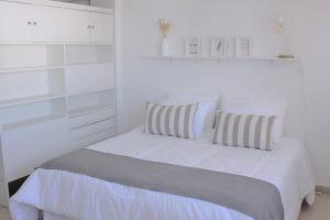 1 dormitorio blanco con 1 cama blanca y 2 almohadas en JUNI0904 Moderno y Espectacular Depto Entero en Recoleta en Buenos Aires