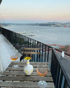 un tavolo con due bicchieri di vino e un vaso sopra di Art Loft , 270* full sea view in Cihangir a Istanbul