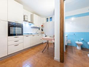a kitchen with white cabinets and a table at VILLA CLAUDIO e LUNETTA in Villasimius