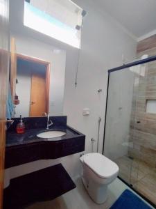 een badkamer met een toilet, een wastafel en een douche bij casa completa, 2 quartos com ar-condicionado, no centro hoteleiro in Andradina