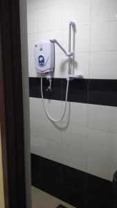 a bathroom with a soap dispenser on a wall at Stephanie Hotel in Teluk Intan