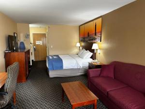 a hotel room with a bed and a couch at Days Inn by Wyndham Imlay City in Imlay City