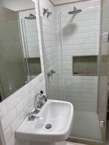 y baño blanco con lavabo y ducha. en My House Copacabana, en Río de Janeiro