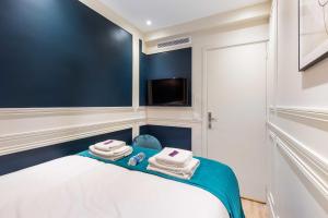 een kleine kamer met een bed met handdoeken erop bij Cosy Appart - 3BR6P Jardin du Luxembourg Odeon in Parijs