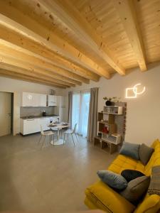 ein Wohnzimmer mit einem gelben Sofa und einem Tisch in der Unterkunft Brothers' Suites in Pisogne