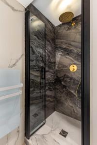 een douche met een glazen deur in de badkamer bij Cosy Appart - 3BR6P Jardin du Luxembourg Odeon in Parijs