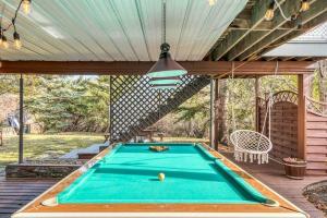 een pooltafel op een terras met zonnescherm bij Boho Retreat w/King Bed on Bow River Pathway in Calgary