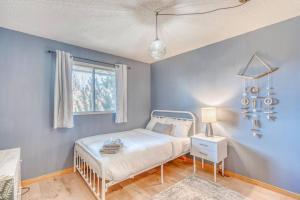 a blue bedroom with a bed and a window at Boho Retreat w/King Bed on Bow River Pathway in Calgary