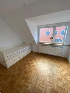 een zolderkamer met een bed en een raam bij Findorff in Bremen