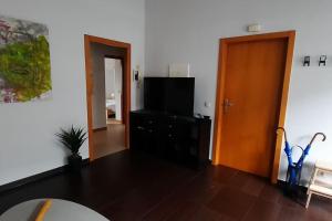 a living room with a television and a wooden door at Luz de Vigo in Vigo