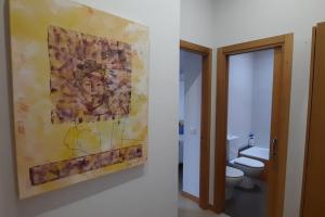 a bathroom with a painting on the wall and a toilet at Luz de Vigo in Vigo