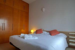 a bedroom with a large white bed with red pillows at Luz de Vigo in Vigo