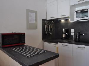 Kuchnia z czarnym blatem i czerwoną kuchenką mikrofalową w obiekcie Bel appartement à Châtel près du centre et des télécabines, avec Multi Pass été à 3€/jour/personne - FR-1-693-63 w mieście Châtel
