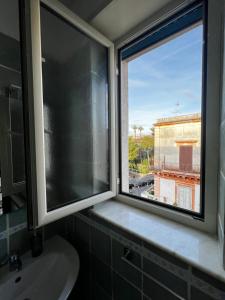 een badkamer met een raam met een wastafel en uitzicht bij RaRoom Colors in Portici