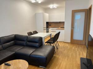 a living room with a couch and a table and a kitchen at Apartman Holesovice,balkon,garaz in Prague