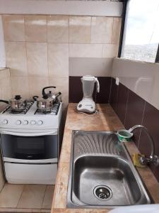 a small kitchen with a stove and a sink at Hostal Don Cristobal in Ayacucho