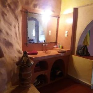 La salle de bains est pourvue d'un lavabo et d'un miroir. dans l'établissement Kasbah Tinariwin, à Taziricht