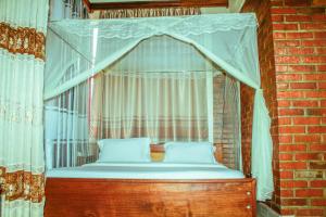 a bedroom with a canopy bed in a brick wall at Heartland hotel in Kigali