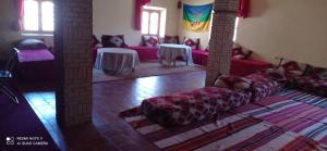 - un salon avec des canapés et des tables dans l'établissement Kasbah Tinariwin, à Taziricht