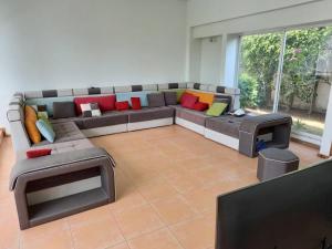 - un salon avec un grand canapé et des oreillers colorés dans l'établissement Casa para 13 en Cuerna, à Acapantzingo