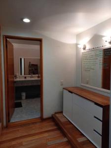 La salle de bains est pourvue d'une coiffeuse avec un miroir et un lavabo. dans l'établissement Casa para 13 en Cuerna, à Acapantzingo