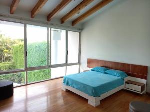 - une chambre avec un lit et une grande fenêtre dans l'établissement Casa para 13 en Cuerna, à Acapantzingo