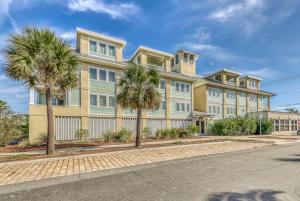 a large yellow building with palm trees in front of it at Berniewood in Tybee Island