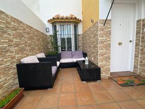 patio con sofá, mesa y pared de ladrillo en Fantástico unifamiliar muy luminoso y tranquilo, en San Fernando