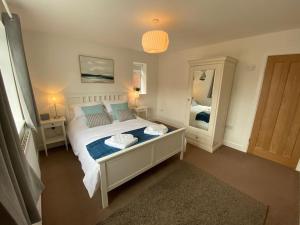 a bedroom with a large bed and a mirror at The North Bay Hideaway, Scarborough in Scarborough