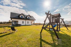 einen Spielplatz im Hof eines Hauses in der Unterkunft DOMKI BILIKÓWKA in Polańczyk